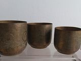 three cups sitting on a clear shelf next to each other