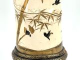 a vase that has birds on it on a stand
