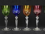six different colored wine glasses are lined up in a row