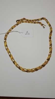 a close up of a gold necklace on a white surface