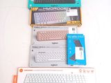 a lot of computer keyboards and a laptop on the table