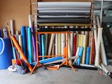de nombreux rouleaux de tissu posés par terre à côté d'un présentoir