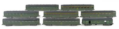 six green train cars sitting next to each other on a white surface