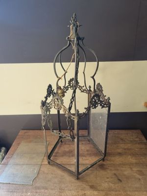 a metal object on a wooden table with a striped wall in the background