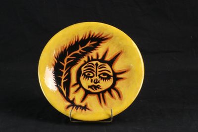 une assiette jaune ornée d'un motif noir et orange