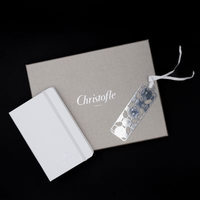 un coffret cadeau ouvert, orné d'un ruban blanc et d'une étiquette argentée