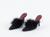 une paire de chaussures noires ornées de plumes sur les orteils