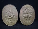 pair of antique silver plated medallions with flowers and leaves