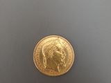 gros plan d'une pièce d'or sur une surface blanche
