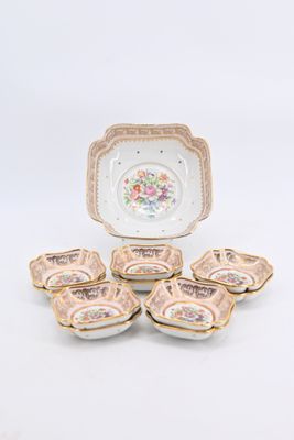 several pieces of porcelain dishes are sitting on a white surface