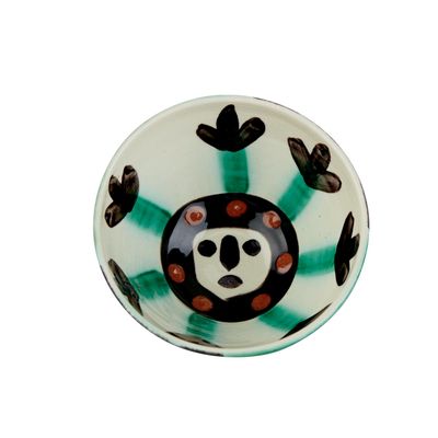 un bol blanc orné d'un motif noir et vert