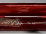 a silver spoon in a red case with a rose on it