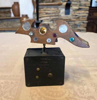 un gros plan d'une sculpture représentant un oiseau posé sur un bloc de bois