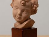 a small statue of a child on a wooden stand