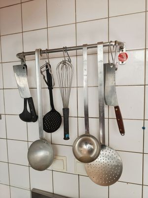 de nombreux ustensiles de cuisine accrochés au mur