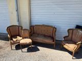 three chairs and a couch sitting in front of a white wall