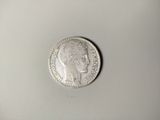 a close up of a silver coin on a white surface