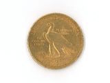 a gold coin with a bird on it on a white surface