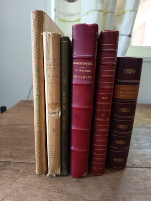 Plusieurs vieux livres sont empilés les uns sur les autres sur une table en bois