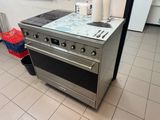une cuisinière qui se trouve dans une cuisine, avec une casserole posée dessus