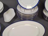 a lot of white and blue plates and bowls on the table