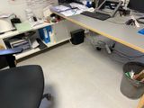 a desk with a computer and a trash can on it