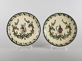 pair of green and white plates with birds and vines on them