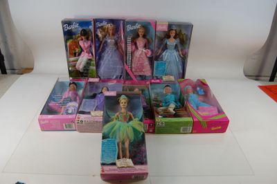 tout un tas de poupées Barbie posées sur la table