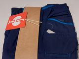 three pairs of blue pants with a tag on a white table