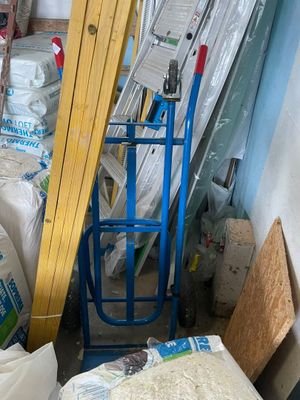 une pile de sacs et un chariot dans une pièce