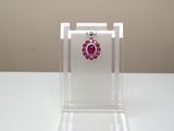 vitrine à bijoux en acrylique transparent sur laquelle est posée une paire de boucles d'oreilles