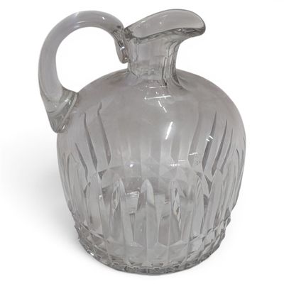 a clear glass pitcher with a handle on a white surface