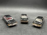 four toy cars are lined up in a row on a table