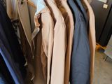 des vêtements suspendus à un portant dans un magasin de vêtements, à côté d'un réfrigérateur