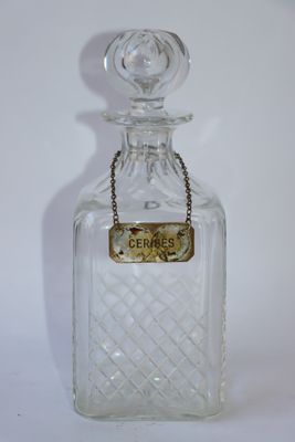 une bouteille en verre transparent avec une chaîne autour du goulot