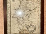 an old map of the country of new york hangs on a wall