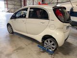 a small white car that is parked in a garage