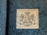 a blue book with a picture of a coat of arms on it