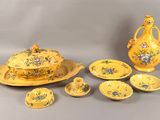 une table dressée en jaune, avec un vase, un bol, une assiette et des tasses