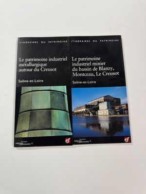 two books on a white surface with a building in the background