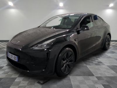 La Tesla Model Y noire est garée dans une pièce dont le sol est en damier.