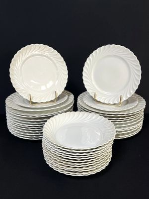 plusieurs assiettes blanches empilées les unes sur les autres sur une surface noire