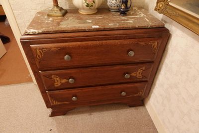 une petite commode sur laquelle est posée une lampe