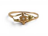 Gros plan sur une bague en or ornée d'une fleur