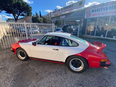 une photo d'une voiture rouge et blanche garée devant un magasin