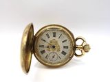a gold pocket watch with roman numerals on it