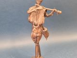 figurine en bronze représentant un homme jouant de la flûte sur un fond bleu
