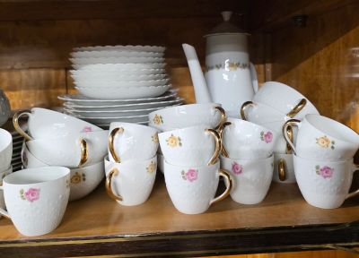 de nombreuses tasses et soucoupes posées sur une étagère dans un vaisselier