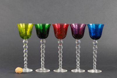 quatre verres à vin de couleurs différentes posés les uns à côté des autres sur une table