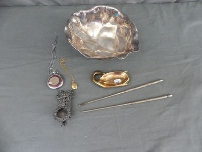 un bol en argent, une cuillère et d'autres objets posés sur une table